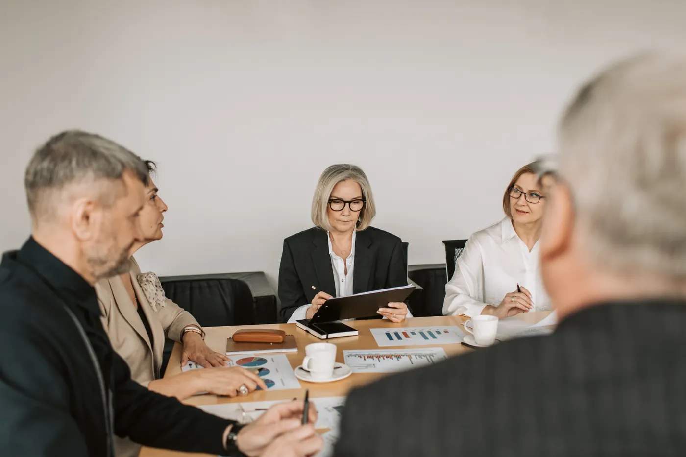 Business professionals discussing priorities around a meeting table
